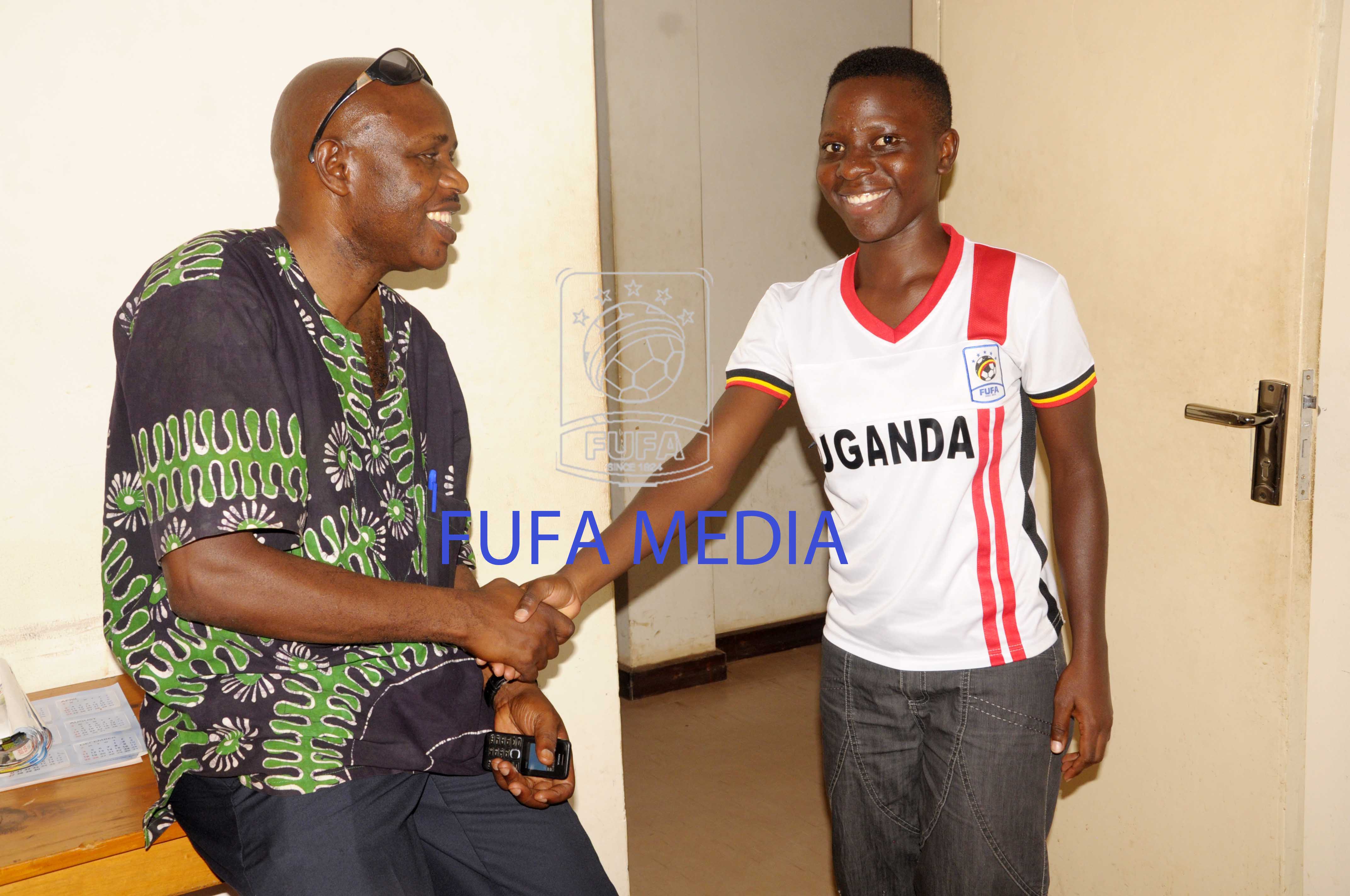 Female footballer of the year Sandra Nabweteme (r) greeting FUFA finance director Decoras Kizza on her courtesy visit to the federation offices today afternoon.2