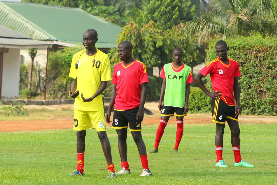 Head Coach Onen Peter (in Yellow) instructs players during one of the training sessions i n Dar es Salaam